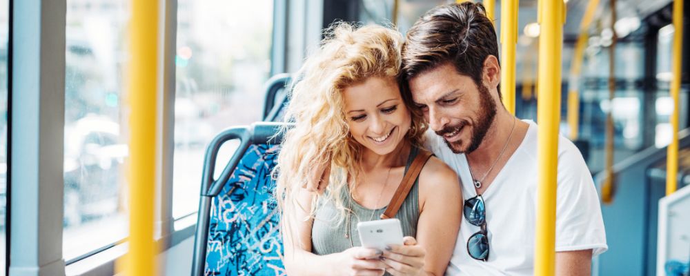 Couple looking at a phone on a bus